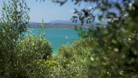 wide establishing shot of boats in the lake, on jamaica beach, sirmione, lago garda, lake garda, italy