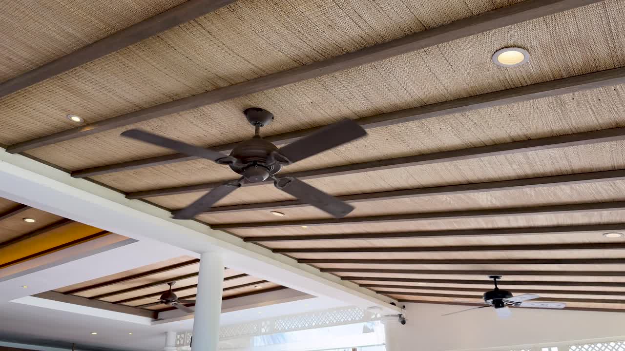 Ceiling fans spinning smoothly in a bright, contemporary Phuket interior with natural lighting