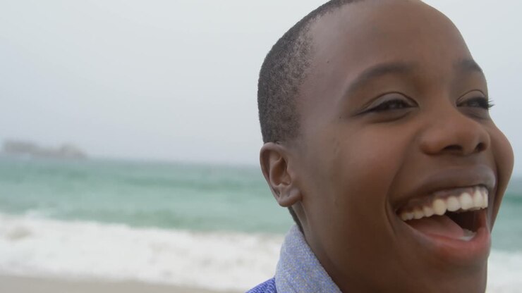 Primo piano di una donna afroamericana sorridente sulla spiaggia 4k