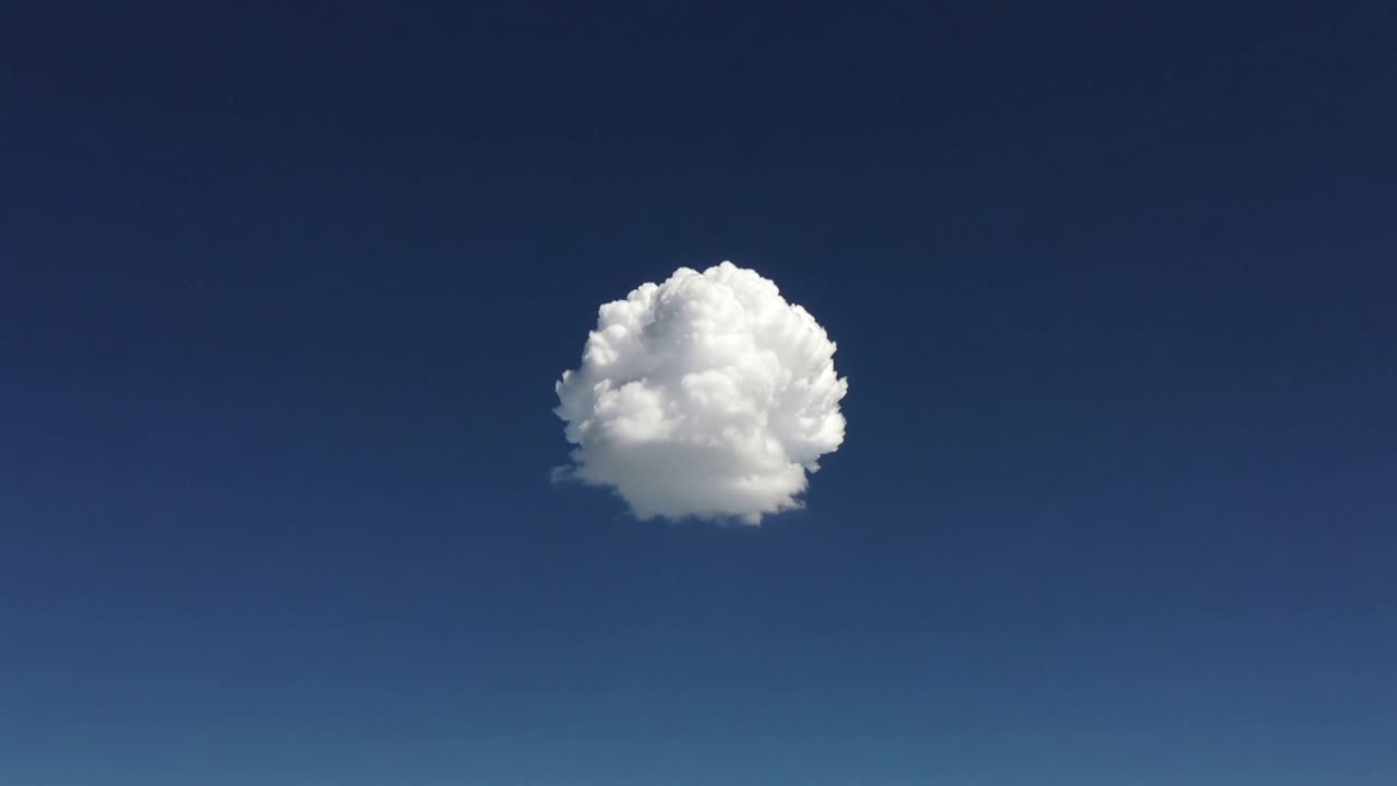 上昇気流により、深い青空に一つの白い積雲が成長し、カリフラワーのような塊を形成している。