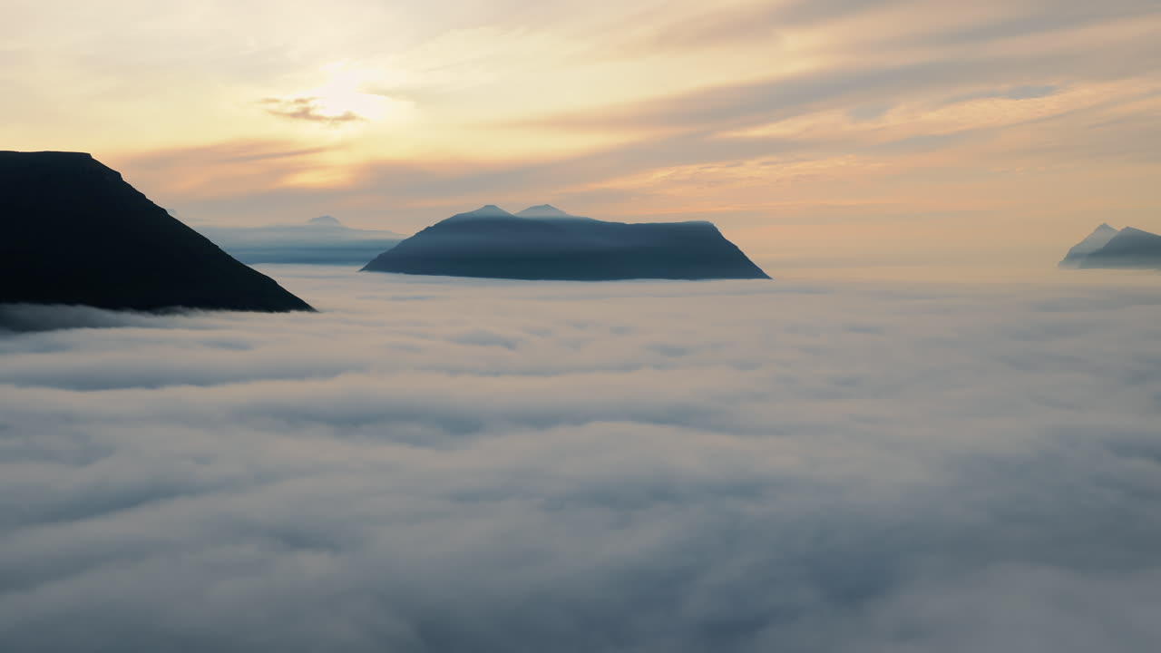 Mountains Emerging from a Sea of Clouds at Sunrise or Sunset