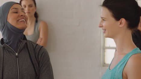 beautiful young muslim woman chatting to friend in yoga class discussing healthy fitness lifestyle sharing training tips enjoying conversation in studio wearing headscarf