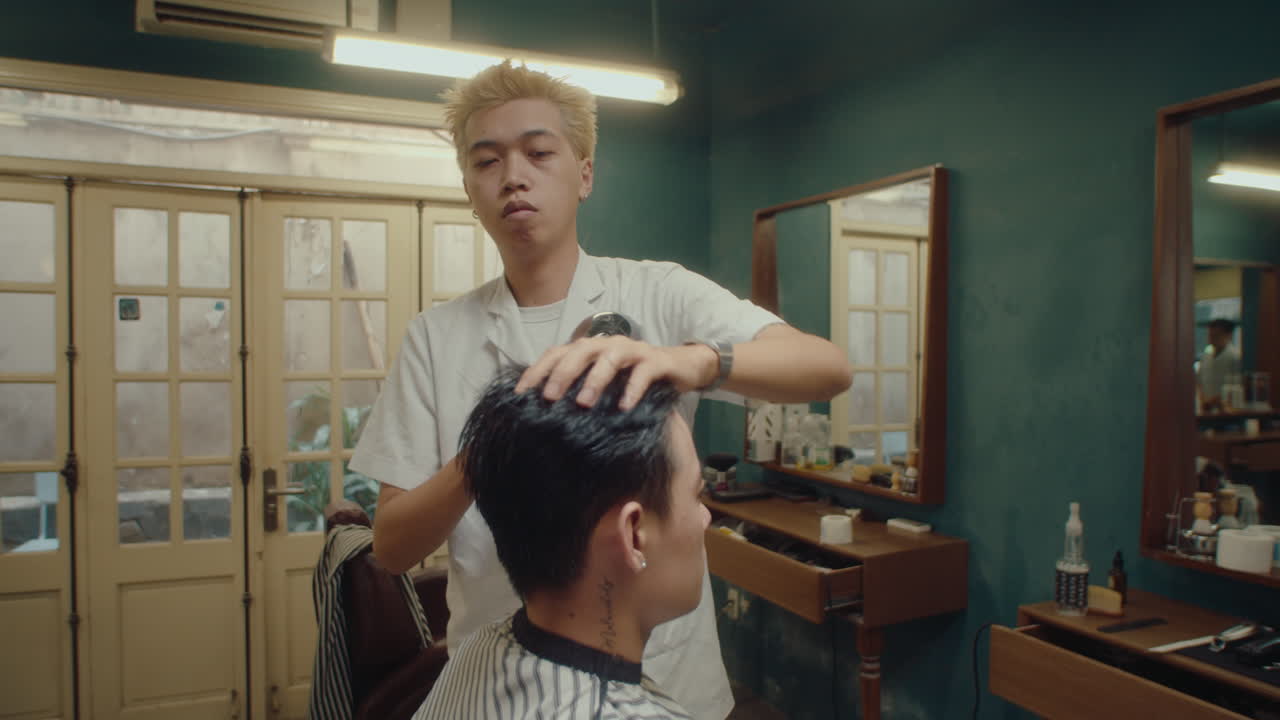Barber Drying Hair of Man after Giving Haircut in the Barbershop