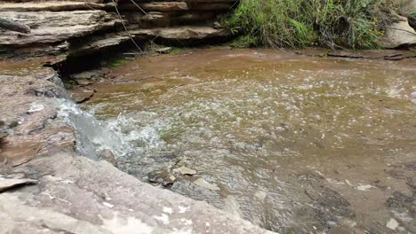 mountain-spring-water-stream-running-down-huge-sandstone-slabs-of-rock-with-green-moss,-algae-and-green-plants---crystal-clear-drinking-water,-meditation-tranquil-and-peaceful-calming-outdoor-nature