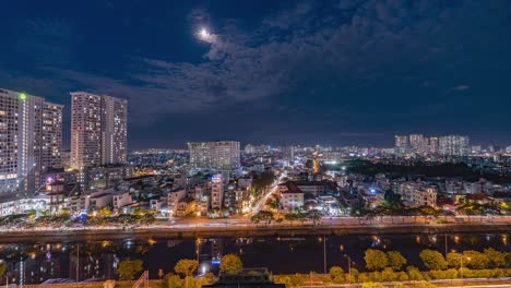 saigon - night time lapse with clouds passing the moon light sky - high wide, south view - vietnam, ho chi minh city