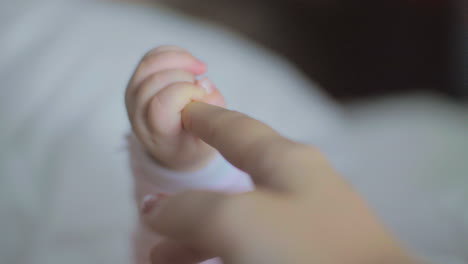 hija bebé sosteniendo el dedo de mamá