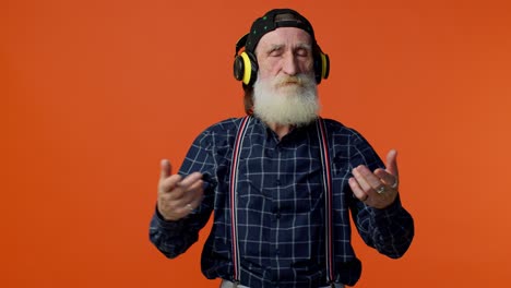 hombre de edad avanzada escuchando música en auriculares bailando discoteca divirtiéndose gesticulando las manos