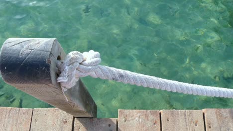 a rope from a footbridge over the turquoise water of mediterranean sea