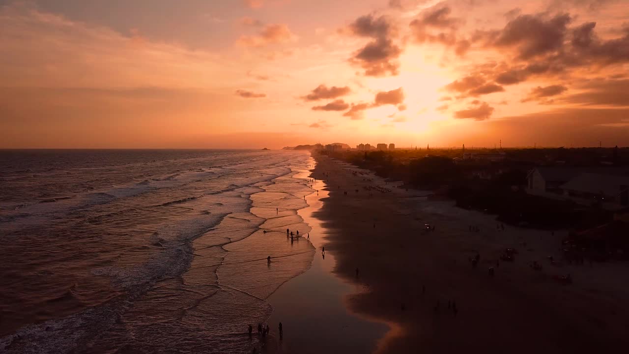 Ripresa aerea di un tramonto mozzafiato su una spiaggia brasiliana, cielo spettacolare e onde