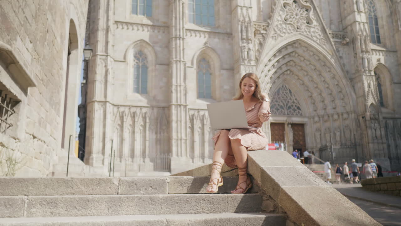 mujer trabajando con una computadora portátil cerca de la catedral