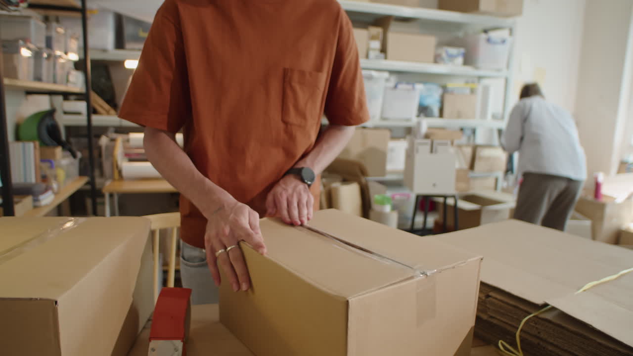 Male Worker Making Cardboard Box in Delivery Service Office