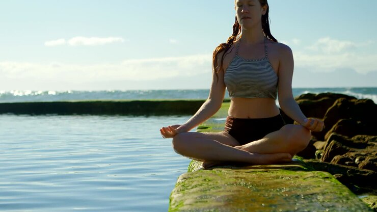 Mujer practicando yoga en la playa 4k