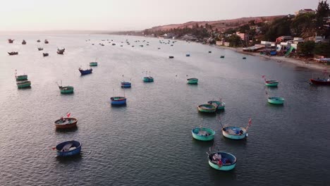 Backwards-flying-over-traditional-vietnamese-fisherman-boats-in-bay-of-Mui-Ne