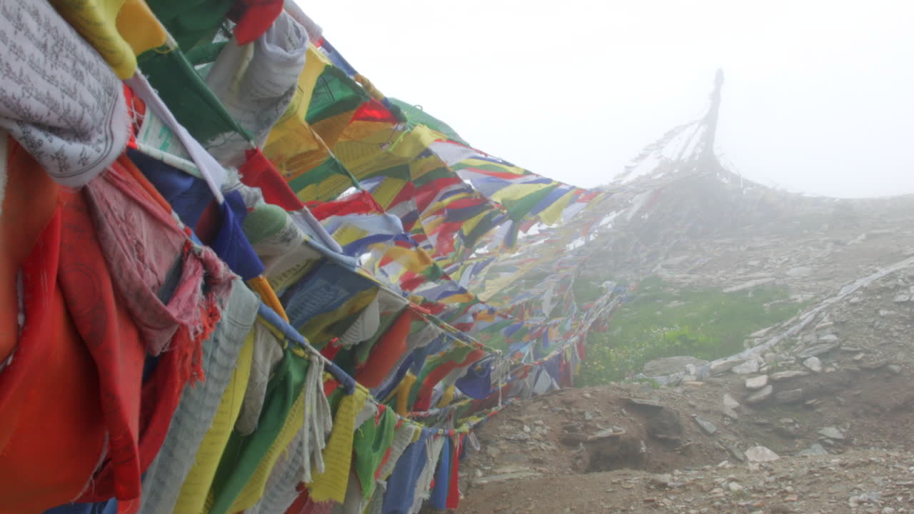banderas de oración tibetanas en el himalaya en la niebla