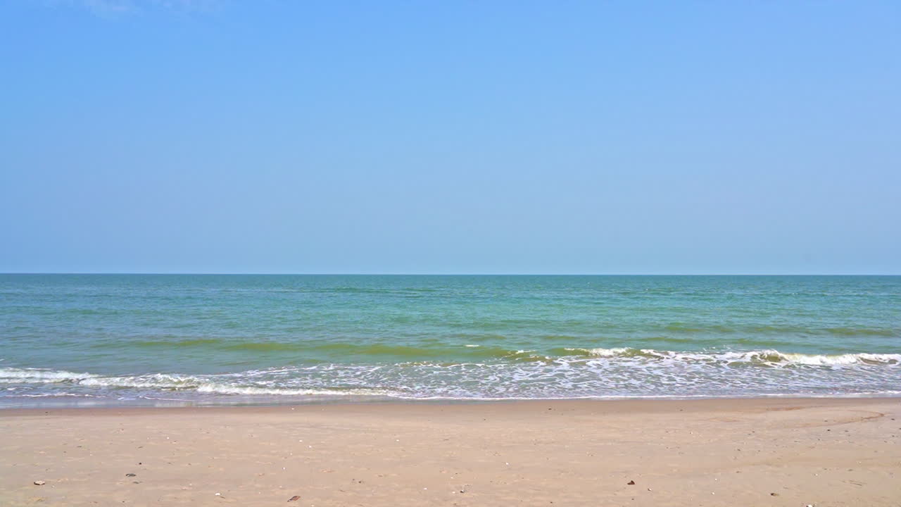 Tropical beach with deep blue sea and skyscape view. Soft waves on the beach