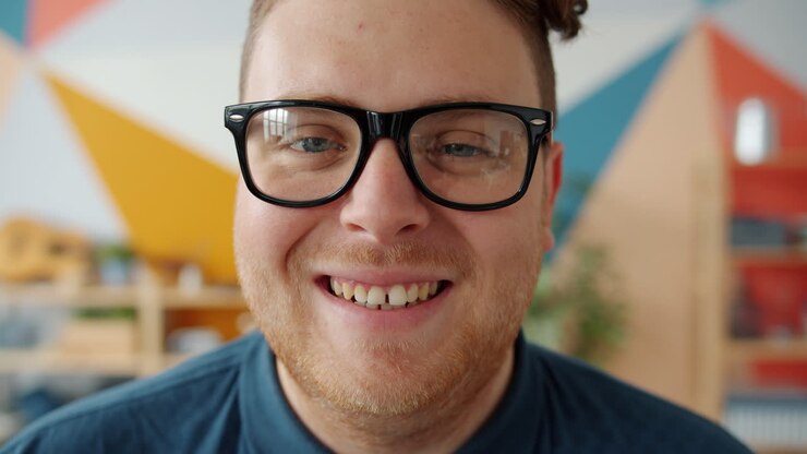 L'uomo sorridente con gli occhiali