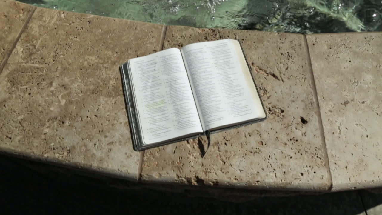 libro sagrado por un fondo de fuente de agua pacífica en cámara lenta