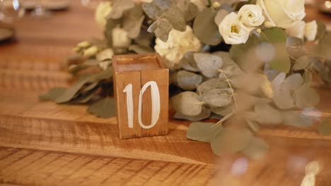 wooden table number and soft floral arrangement in rustic elegant wedding table decor