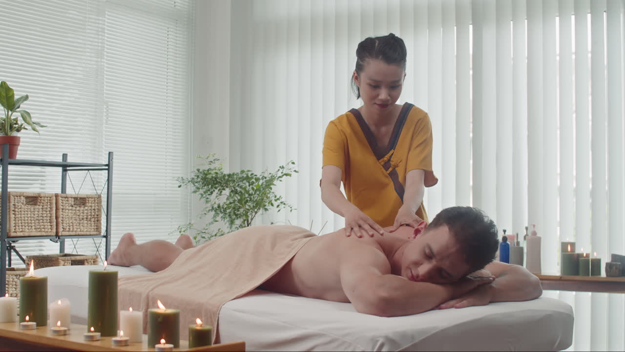 Woman Doing Spa Massage on Mans Back