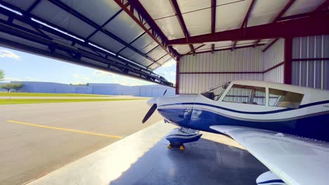 hangar door opens to reveal piper cherokee 180