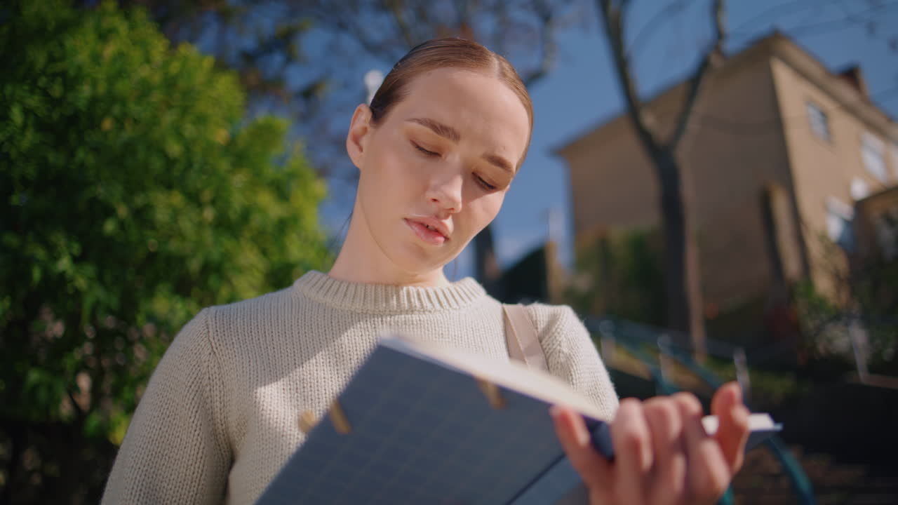 Student woman using notebook at sunlight closeup. Focused lady enjoying break