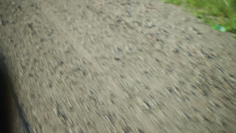 a blurred motion view of a gravel road surface as the ground rushes by