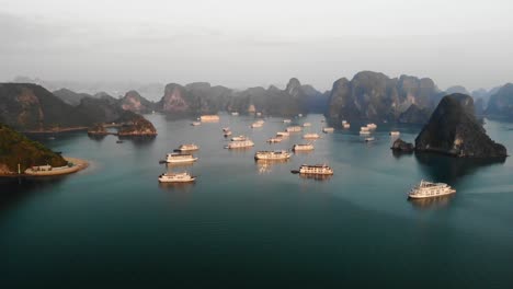 scenic aerial view of hạ long bay, in northeast vietnam, cruise yacht luxury boat moored at sunrise in heavenly bay with rocky islets and clear pristine water