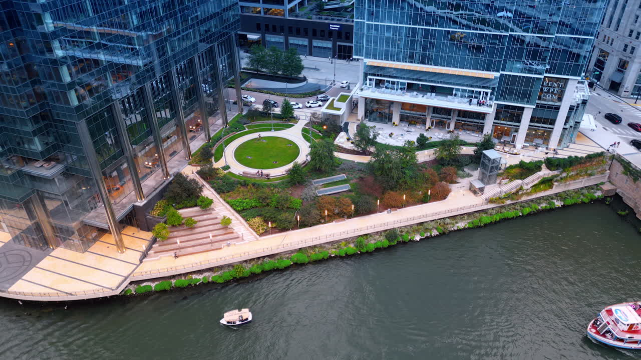 Chicago, USA, 29 June 2025: Lovely green area with landscape design at the river waterfront. Aerial perspective on the vehicles moving by the Chicago River