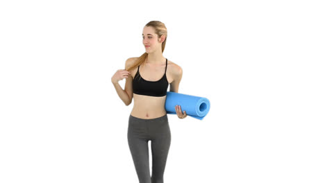 Slim-model-waving-and-holding-exercise-mat