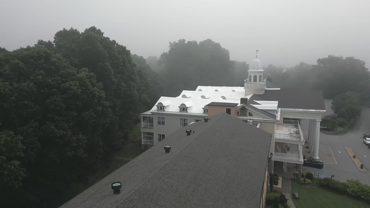 안개 가 가득 한 공중 비행기 가 주나루스카 호수 에 있는 람부스 인 의 지붕 위 를 낮게 날아간다
