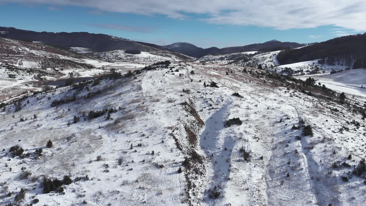 lento aéreo sobre las llanuras montañosas cubiertas de nieve día soleado de invierno