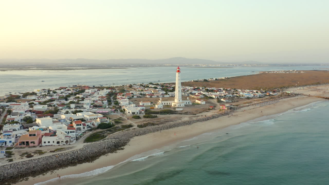 Low aerial orbit Farol Lighthouse village Ilha do Farol Algarve