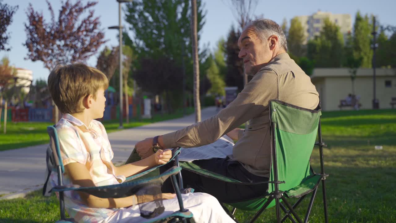 el abuelo está charlando con su nieto al aire libre.