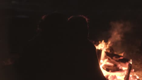 couple by a campfire at night