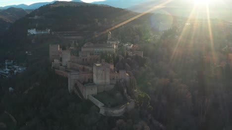 aerial drone of alhambra medieval complex, islamic palace on the hilltop at sunrise in granada, andalusia, spain