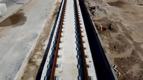 aerial forward drone shot of an empty light rail tracks on construction in jaffa, israel