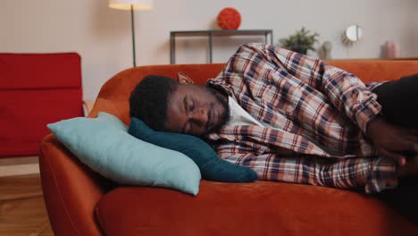 overworked african american man falling asleep on sofa after party lack of energy breakdown