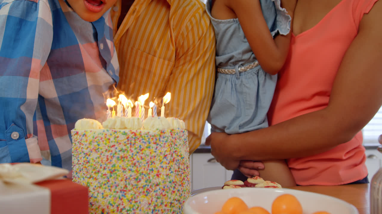 sección media de la familia negra celebrando cumpleaños en la cocina de una casa cómoda 4k