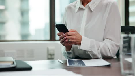 woman using smartphone at office desk