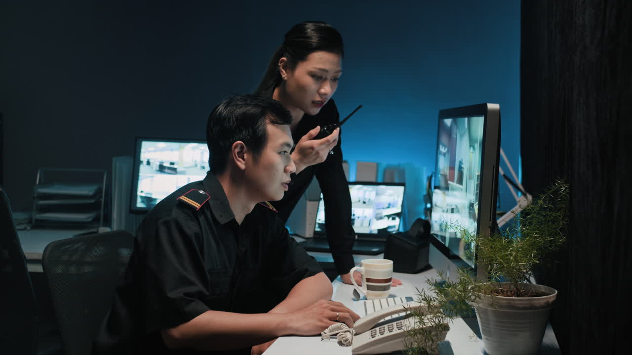 Asian Guards Working Together at Surveillance Room