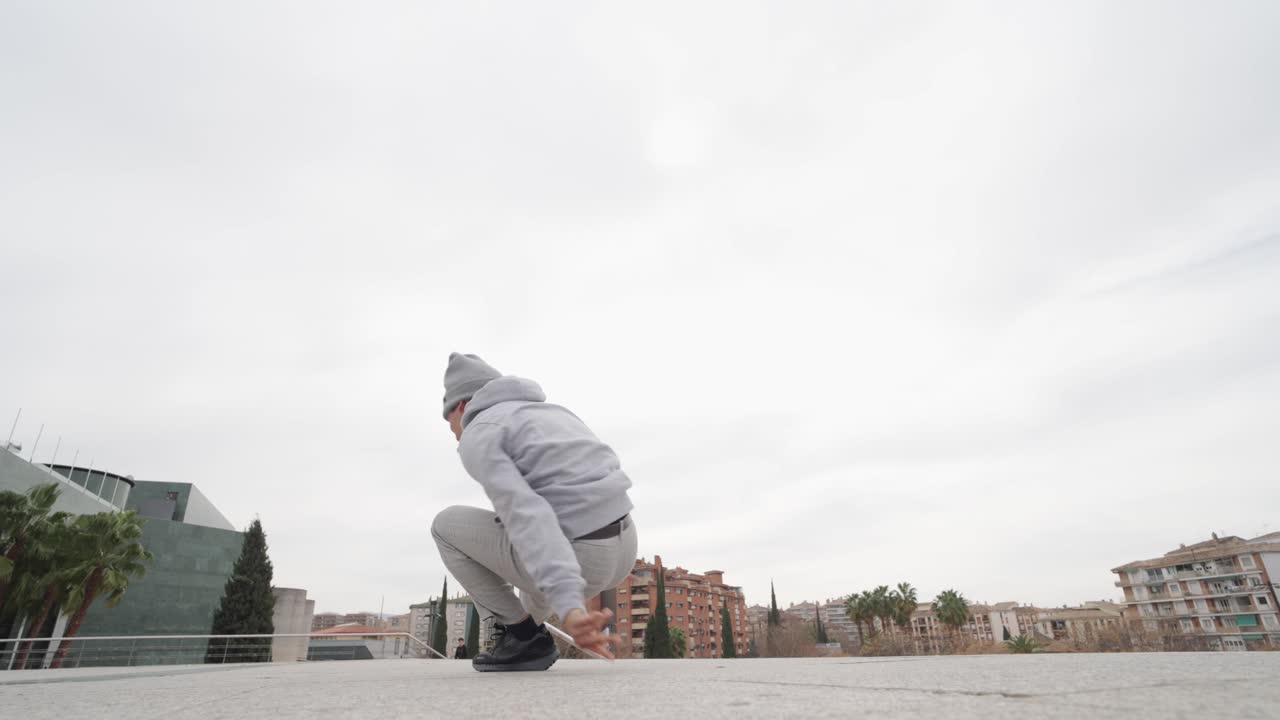 Breakdancer performing freeze and power moves outdoors