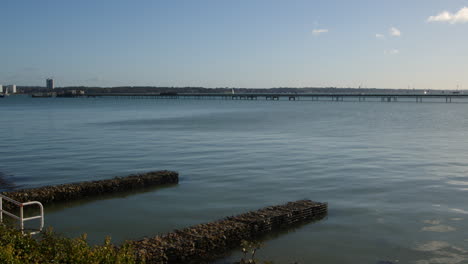 Hythe-Railway-Pier-train-going-right-to-left-of-frame-with-the-ferry-docking,-Taken-from-Hythe-Marina