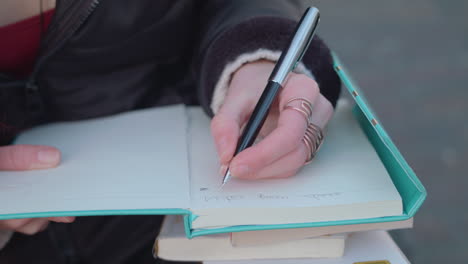 young lady thinking about what to write in her note book