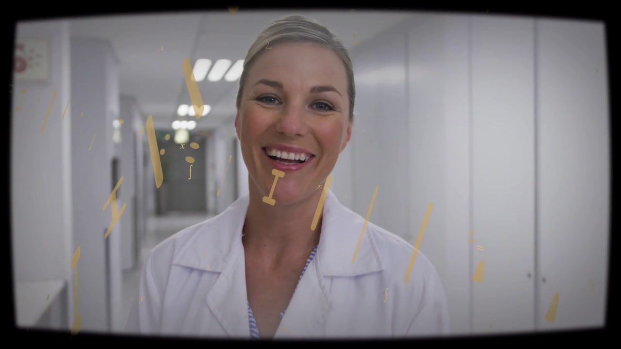 Medico sorridente che indossa un camice bianco da laboratorio e un top a righe con un ciondolo in un lungo corridoio, con una sovrapposizione dorata.