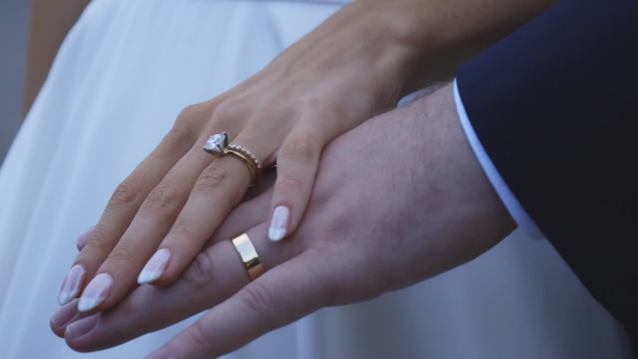 Bride and groom rest hands during sunset