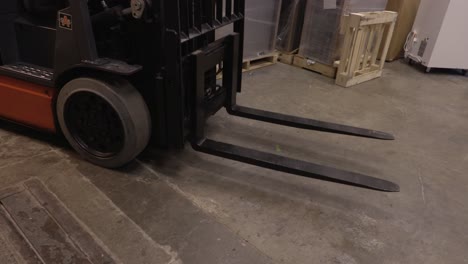 blue collar worker lowering the forks of an electric fork lift