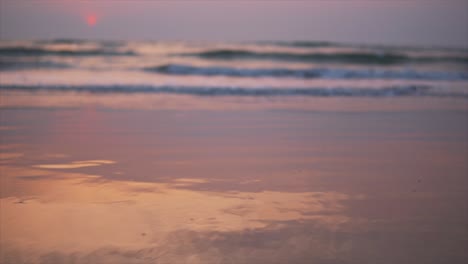 vista de las olas del mar en la orilla arenosa, puesta de sol y reflejo en la playa, estática