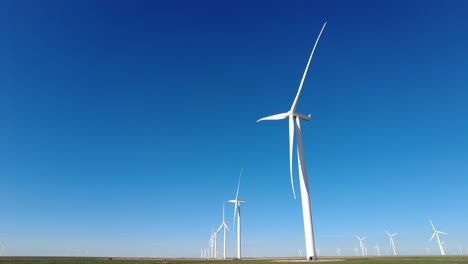 a field of wind turbines slowly spinning in rural west texas