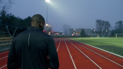 man running on a track at night