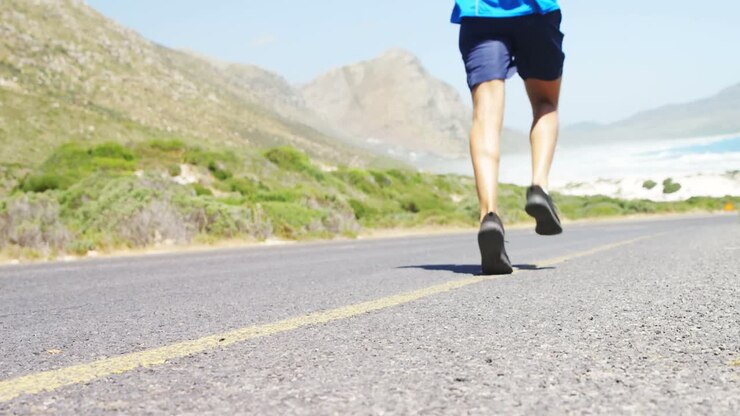 Triatleta uomo che fa jogging su una strada di campagna